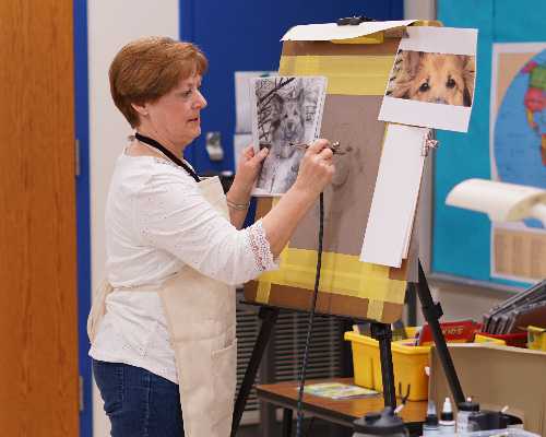 Melanie Hollingsworth paints an animal.