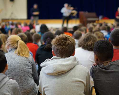Students at Kissel Hill listen to a violist play.