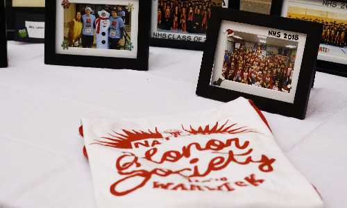 National Honor Society t-shirt on table with photos.
