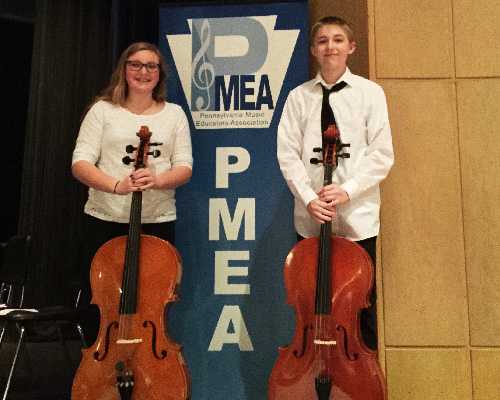 students pose for photo with string instruments